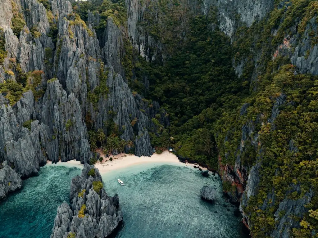 Calm turquoise water and limestone cliffs in Bacuit Bay, El Nido, in dry-season conditions