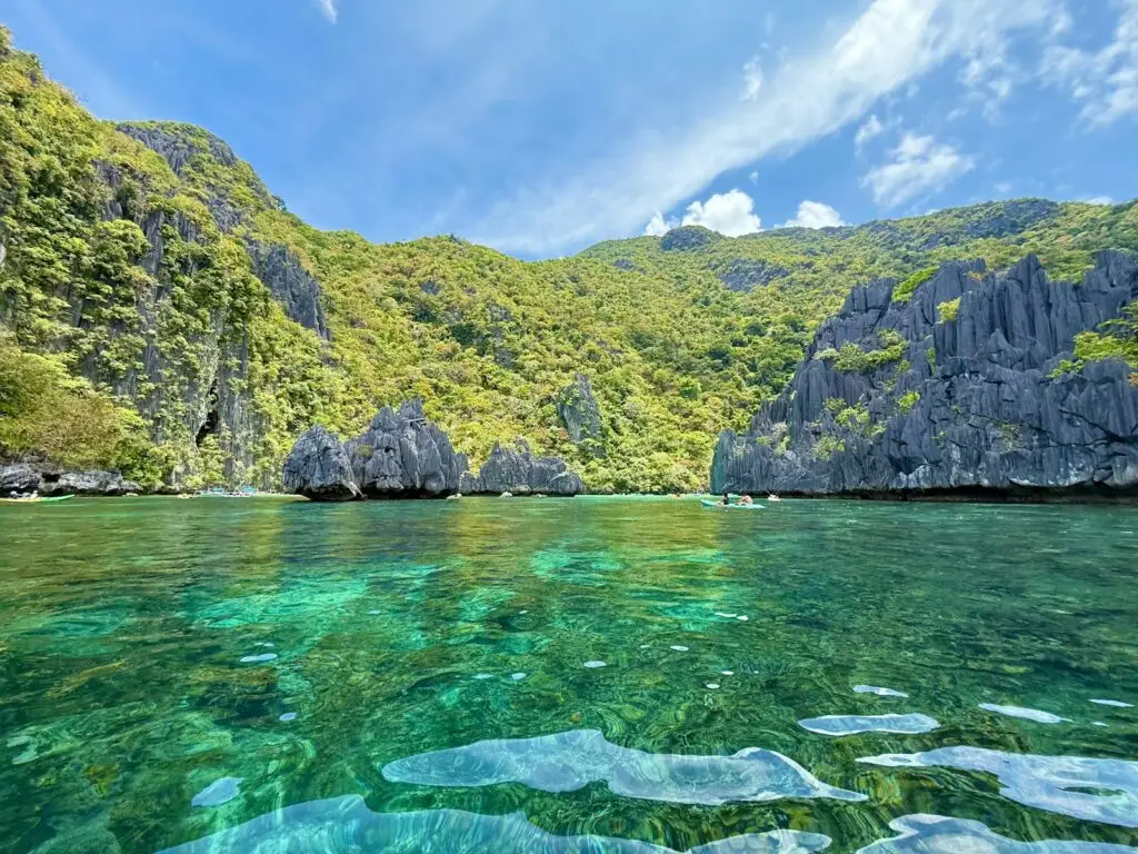 Beautiful turquoise lagoon surrounded by lush green limestone cliffs in El Nido Palawan Philippines